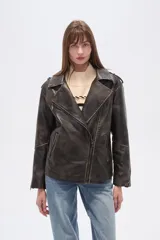 Chaqueta estilo biker de eco-cuero con efecto desgastado, color negro. Presenta cuello solapa, cierre asimétrico frontal, bolsillos con cierre y hombreras.