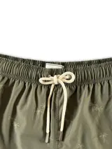 Short de baño blanco con estampado de hojas de palmera en tonos verde, rojo y amarillo.