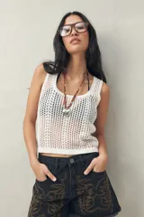 Top blanco de tejido crochet con cuello redondo y sin mangas.
