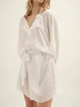 Bata color blanco con estampado de lunares, mangas largas y lazo para ajustar en la cintura.