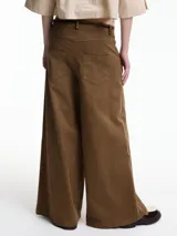 Pantalón ancho color marrón, con pretina con botón metálico y pasacinto. Incluye cinto fino de cuerina negra.