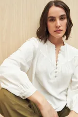 Camisa celeste de manga larga en viscosa suave, con cuello mao y botonadura parcial al frente. El detalle de frunces en los hombros y los puños abotonados le suman delicadeza y estilo.