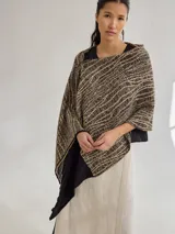 Chal color beige con diseño jacquard, de forma rectangular y caída fluida.