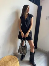 Chaleco corto negro con solapas, doble botonadura y corte sastrero. Sin mangas.