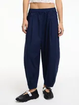 Pantalón negro tipo chino con pinzas delanteras, bolsillos laterales y pretina con elástico.