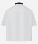 Camisa blanca oversized de tricolina con cuello negro contrastante, mangas cortas y estampado con la palabra "Hustle" en verde y negro.