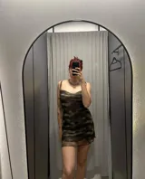 Vestido corto de mesh con estampado abstracto en tonos marrones y negros. Tiene breteles finos, escote drapeado y ruedo asimétrico.