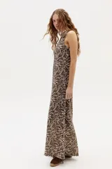 Vestido largo con estampado abstracto en tonos marrones y beige, cuello halter y corte en línea A. Confeccionado en lino 100% natural con terminación metalizada.