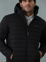 Campera acolchada negra con capucha, cierre frontal con cremallera y bolsillos laterales con cremallera. Logo de Calvin Klein en el pecho.