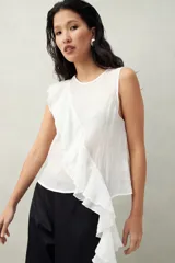 Top blanco de tencel sin mangas, de corte asimétrico, con volados en diagonal.
