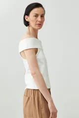 Remera blanca de manga corta con escote Bardot (hombros descubiertos) y calce ajustado.