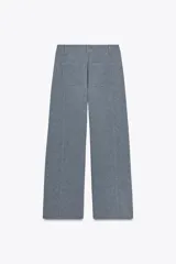 Pantalón de vestir celeste con corte palazzo, tiro alto, bolsillos laterales y cierre frontal con cremallera y botón.