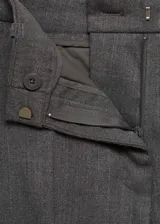 Pantalón de vestir gris oscuro, de corte skinny, tiro medio y largo cropped. Presenta trabillas en la cintura, bolsillos laterales y cierre frontal oculto con botón, gancho y cremallera.