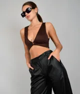 Crop top marrón con escote en V y cierre metálico en el centro.
