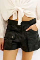 Short cargo negro de cuero vacuno, con múltiples bolsillos frontales con cierres y solapas. Corte por encima de la rodilla.