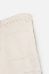 Bermuda color verde militar, de corte relaxed fit, con bolsillos frontales y traseros tipo plaqué, detalle de tira y bolsillo multifunción en la pierna, y bajo irregular.