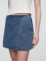 Short pollera de jean color celeste claro, con corte asimétrico y detalle de costuras a la vista.