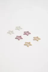 Pack de tres hebillas para el pelo con forma de estrella hueca, en colores blanco, rosa y beige.