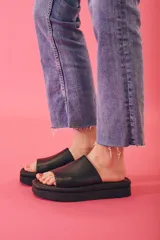 Sandalias negras de cuero sintético con plataforma y tira ancha sobre el empeine.