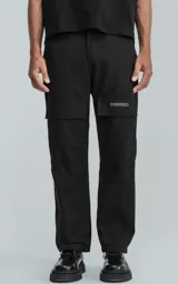 Pantalón cargo negro de corte recto con bolsillos laterales con solapa y etiqueta con texto en la pierna derecha.