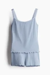 Pijama de dos piezas color celeste en punto acanalado, compuesto por un top de breteles con ribete de encaje en el escote y un short con cintura elástica y bajo sobrehilado.