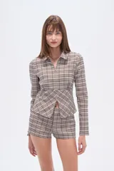 Camisa de viscosa a cuadros en tonos beige, marrón y blanco, con cuello camisero, cierre frontal y corte ajustado al cuerpo.