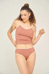 Bombacha de bikini ancha en los costados, de tiro alto y corte cavado. Totalmente forrada, color negro con ribete blanco.