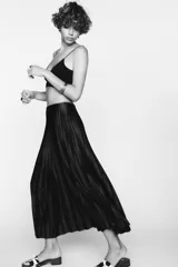 Falda midi plisada color marrón oscuro, de tiro alto y cintura elástica.