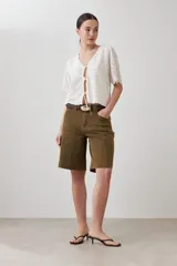Blusa color crudo de broderie con escote en V y cierre frontal con lazos.