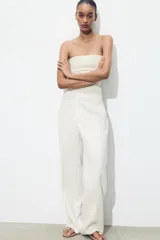 Pantalón de tiro alto color fucsia, con bolsillos delanteros y falsos bolsillos de vivo en la espalda. Tejido con efecto arrugado, pernera recta y cierre frontal con cremallera, botón interior y gancho.