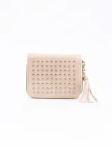 Billetera pequeña color nude con cierre de cremallera y detalle de tachas doradas en el frente. Incluye un colgante de flecos.