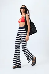 Pantalón tejido con motivo zigzag en tonos beige y blanco, de corte flare y cintura elastizada.