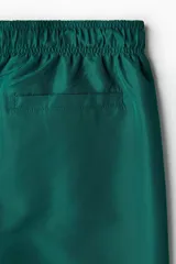 Short de baño verde esmeralda con cintura elástica y cordón ajustable.