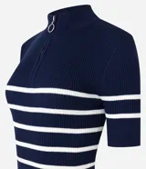 Blusa de tejido de punto acanalado color blanco con rayas horizontales azul marino, cuello polo con cierre metálico y mangas cortas.