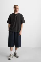 Camiseta negra de corte cuadrado, con cuello redondo, mangas cortas y efecto lavado.