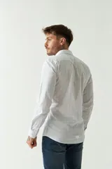 Camisa de hombre a rayas verticales celestes y blancas, corte slim fit, manga larga, logo bordado en el pecho y cartera con botones.