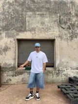 Remera blanca de algodón con corte boxy y parche bordado con la palabra "Brokers" en óvalo azul y verde.