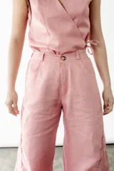Pantalón wide leg color coral rosa, confeccionado en lino. Presenta tiro medio/alto, elástico en la espalda y godets en los bajos.