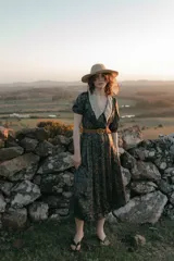 Vestido midi de gasa crepe con estampado floral en tonos verdes y violetas, cuello camisero con detalle de tejido calado y mangas cortas abullonadas.