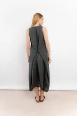 Vestido midi gris oscuro de lino, corte recto y sin mangas. Tiene bolsillos laterales y cuello redondo.