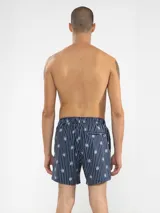 Short de baño celeste con rayas verticales blancas y estampado de flores blancas.