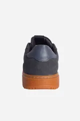 Zapatillas urbanas blancas con detalles en gris, cordones blancos y suela color crema.