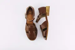 Sandalias de cuero color marrón con tiras entrecruzadas, hebilla lateral y taco cuadrado de madera.