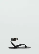 Sandalia de dedo negra con tira al tobillo y hebilla dorada.