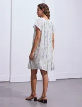 Vestido corto estampado, marca Marissa Olivia. Cuello a la base con frunce y lazo de ajuste. Terminación de ruedo con volado. Forro interno a tono.