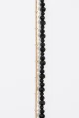 Collar doble, uno con perlitas negras y otro con cadena dorada.