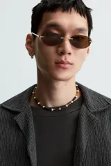 Camisa de manga corta con cuello bowling y calce relajado. Presenta un tejido con textura estructurada y efecto lavado, con cierre frontal de botones al tono.