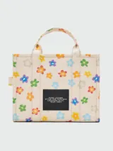 Bolso tote mediano de lona color crema con estampado de margaritas de colores, doble asa corta y correa larga extraíble.