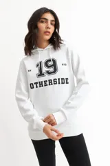 Hoodie gris con capucha y cordones ajustables. Estampado frontal con la palabra 'OTHERSIDE' y las siglas 'OTH' en azul marino.