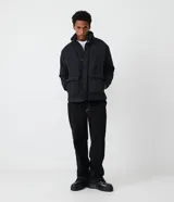 Campera puffer negra para hombre, con cuello alto, cierre frontal con botones a presión, bolsillos laterales y corte holgado. Fabricada en poliéster y poliamida.